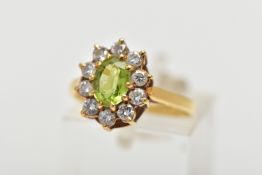 AN 18CT GOLD PERIDOT AND DIAMOND CLUSTER RING, the oval cut peridot, with brilliant cut diamond