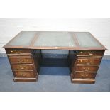 A REPRODUCTION MAHOGANY PEDESTAL DESK, teal leather writing surface, with an arrangement of six