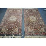 A PAIR OF WOOLKEN KASHAN RUGS, with a red and blue field, 204cm x 126cm and 123cm (condition:-both