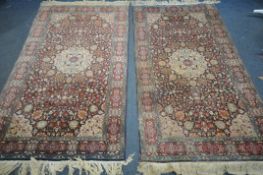 A PAIR OF WOOLKEN KASHAN RUGS, with a red and blue field, 204cm x 126cm and 123cm (condition:-both