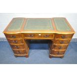 A YEW WOOD KNEE HOLE DESK, with triple green leather writing surface, nine assorted drawers, on