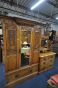 AN EARLY 20TH CENTURY CARVED OAK BEDROOM SUITE, comprising a single mirror door wardrobe, with a