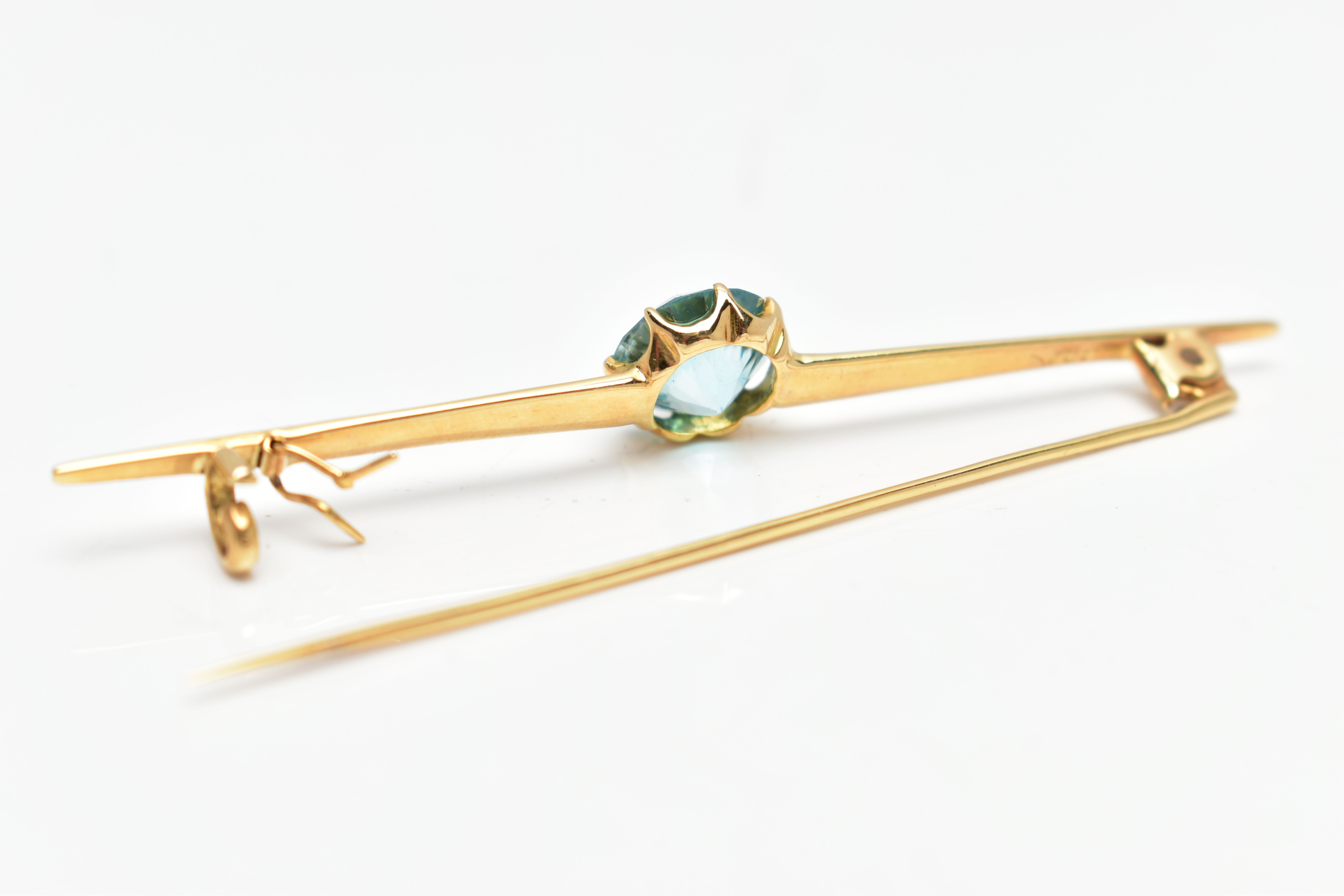 A YELLOW METAL ZIRCON BAR BROOCH, set with a circular blue zircon, measuring approximately 8.5mm x - Image 3 of 3