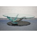 AN GLASS TOP OVAL COFFEE TABLE, the base in the form of an otter hunting a fish, length 140cm x