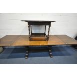 A REPRODUCTION OAK DRAW LEAF REFECTORY TABLE, on a twin turned base, united by a stretcher, extended