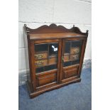 AN EARLY 20TH CENTURY OAK SMOKERS CABINET, with two bevelled glass doors, that enclosing a fitted