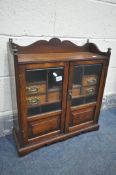 AN EARLY 20TH CENTURY OAK SMOKERS CABINET, with two bevelled glass doors, that enclosing a fitted