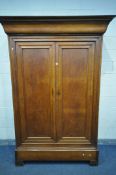 AN EARLY 20TH CENTURY OAK FRENCH ARMOIRE, the double panelled doors over a single long drawer, on