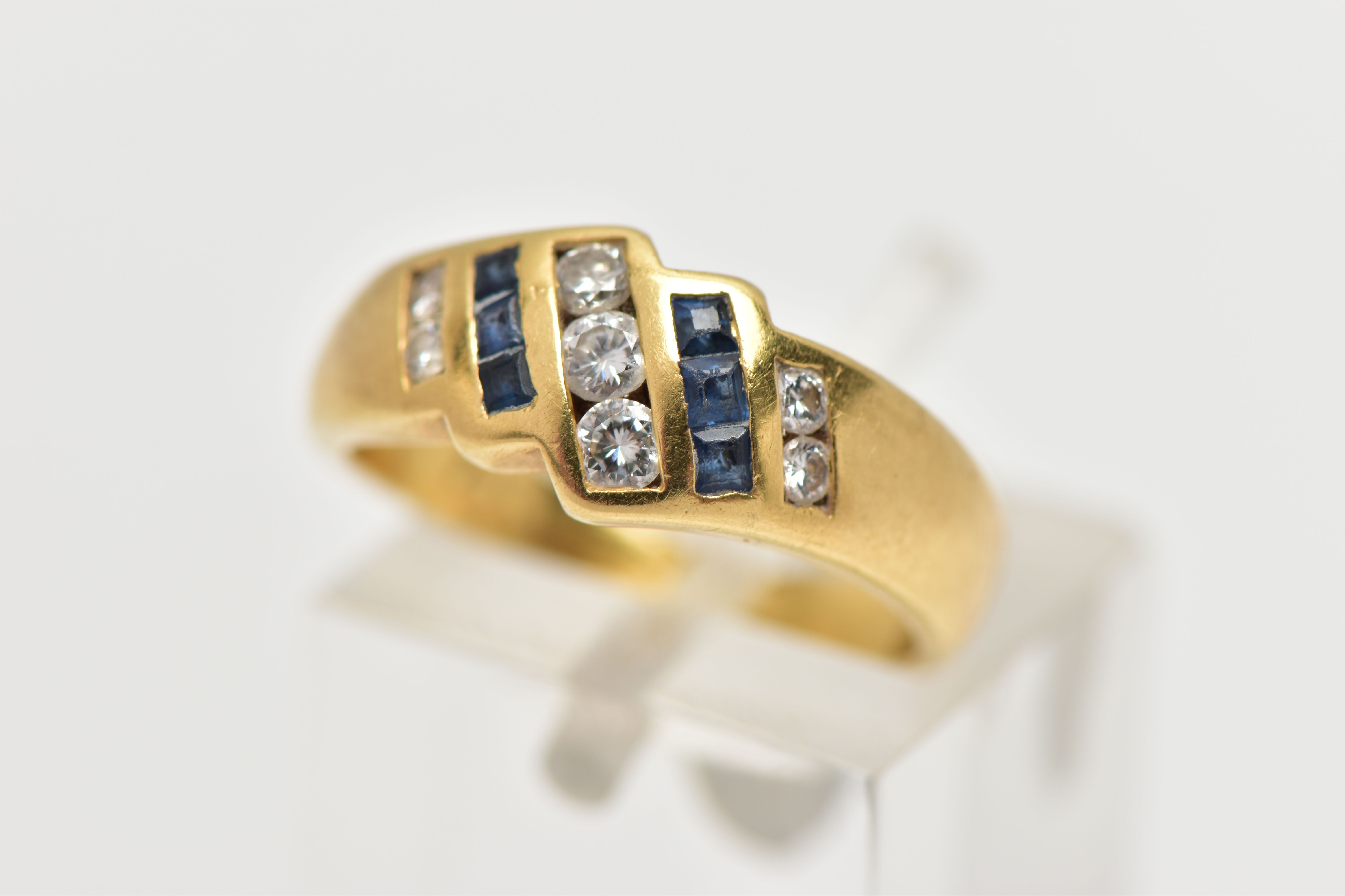 A YELLOW METAL SAPPHIRE AND DIAMOND DRESS RING, of geometric design, the principal brilliant cut