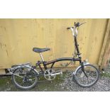 A BROMPTON THREE SPEED FOLDING BICYCLE in black colour some surface scratches and rust spots (all