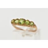 A 9CT GOLD FIVE STONE PERIDOT RING, designed with five graduated circular cut peridots, scrolling