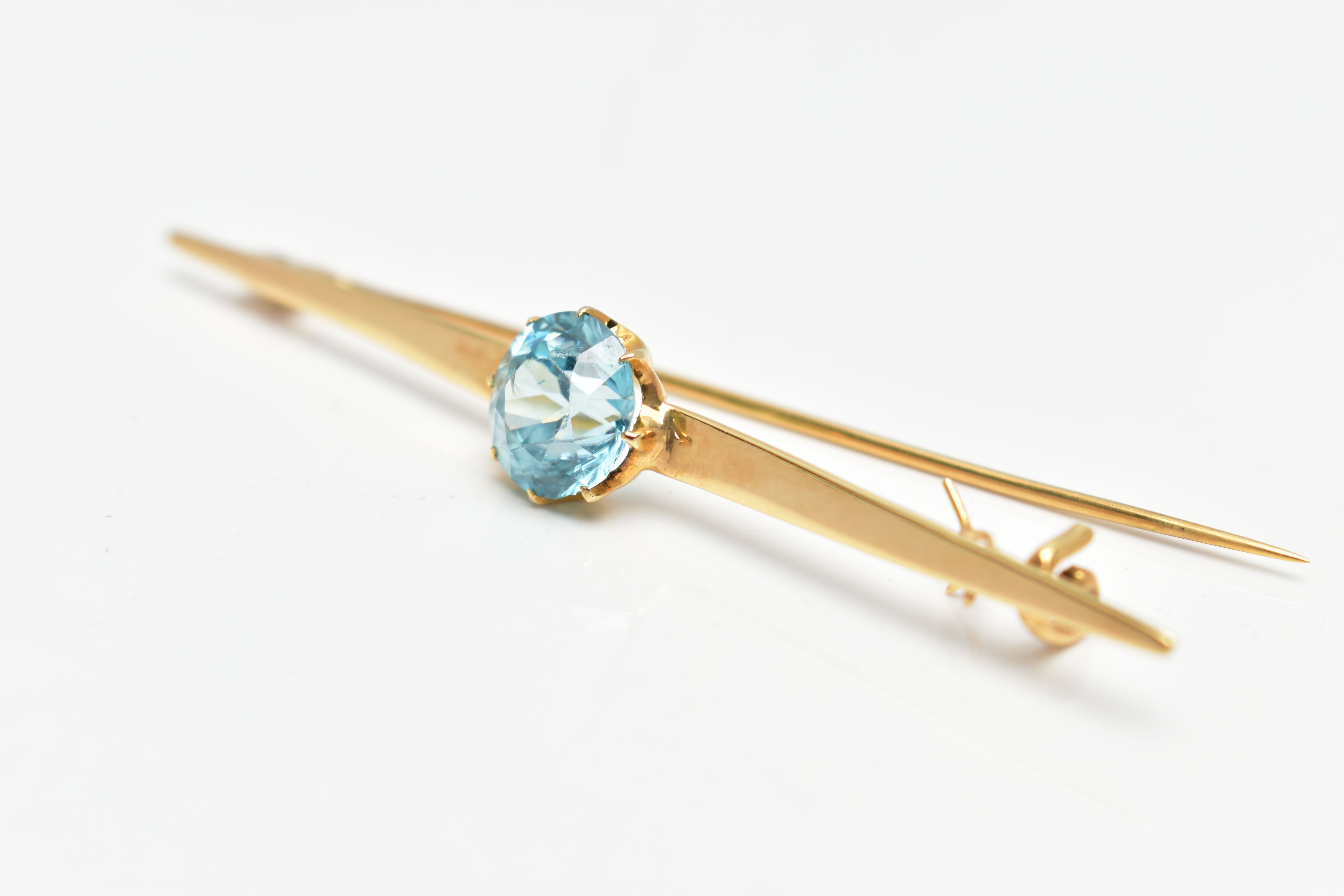 A YELLOW METAL ZIRCON BAR BROOCH, set with a circular blue zircon, measuring approximately 8.5mm x - Image 2 of 3