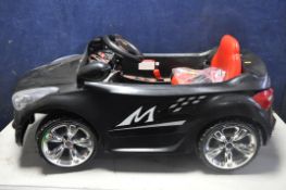 A CHILDRENS ELECTRIC RIDE ON CAR, with remote control capability, charger and instruction manual (