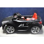 A CHILDRENS ELECTRIC RIDE ON CAR, with remote control capability, charger and instruction manual (