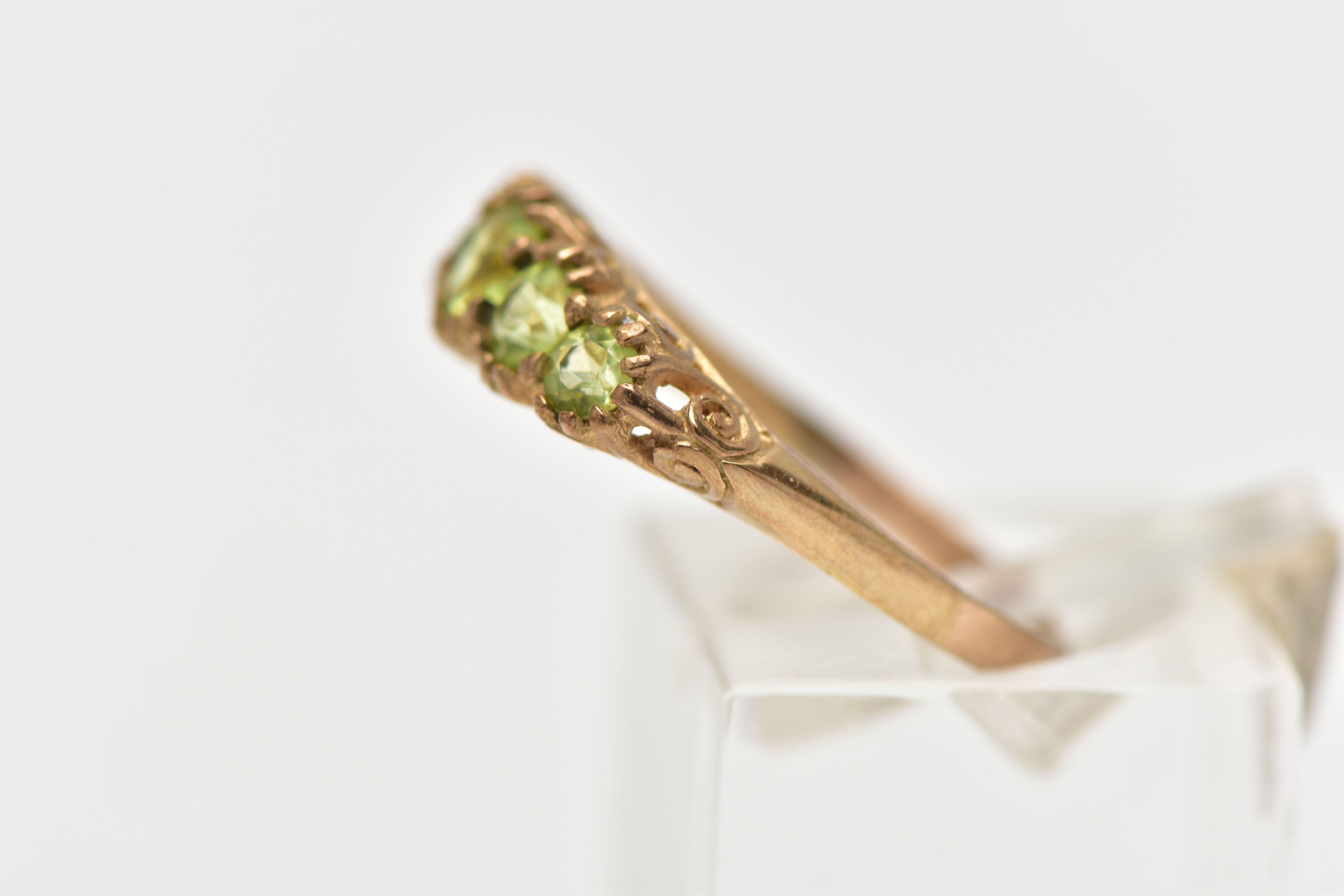 A 9CT GOLD FIVE STONE PERIDOT RING, designed with five graduated circular cut peridots, scrolling - Image 2 of 4