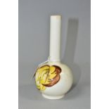 A MOORCROFT POTTERY BUD VASE, 'Leaves in the Wind' yellow and brown leaf pattern on a cream