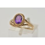 A 9CT GOLD AMETHYST SINGLE STONE RING, the oval cut amethyst within a collet setting, to the