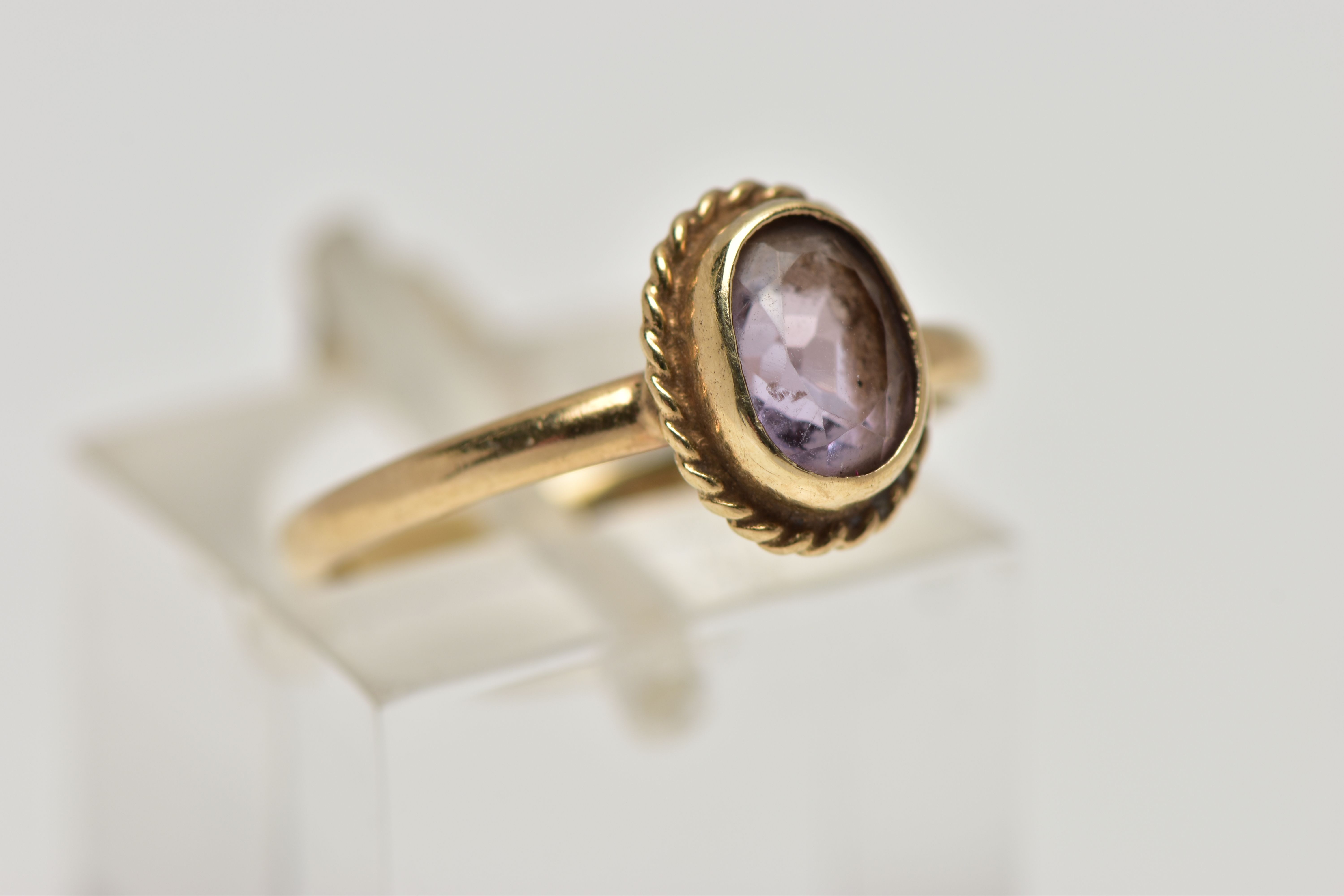 A 9CT GOLD AMETHYST SINGLE STONE RING, the oval cut amethyst within a collet setting, to the rope - Image 4 of 4