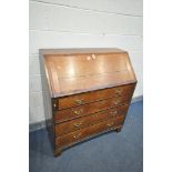 A GEORGIAN OAK AND MAHOGANY CROSSBANDED BUREAU, the fall front enclosing a fitted interior, above