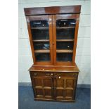A 20TH CENTURY MAHOGANY BOOKCASE, the top with two glazed doors, base with two drawers above two