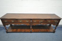 A REPRODUCTION GEORGIAN STYLE OAK DRESSER BASE, with four drawers, wavy apron, three turned and