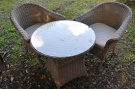 AN LG OUTDOOR RATTAN EFFECT GARDEN SET, to include a circular table, with a glass top, diameter 74cm