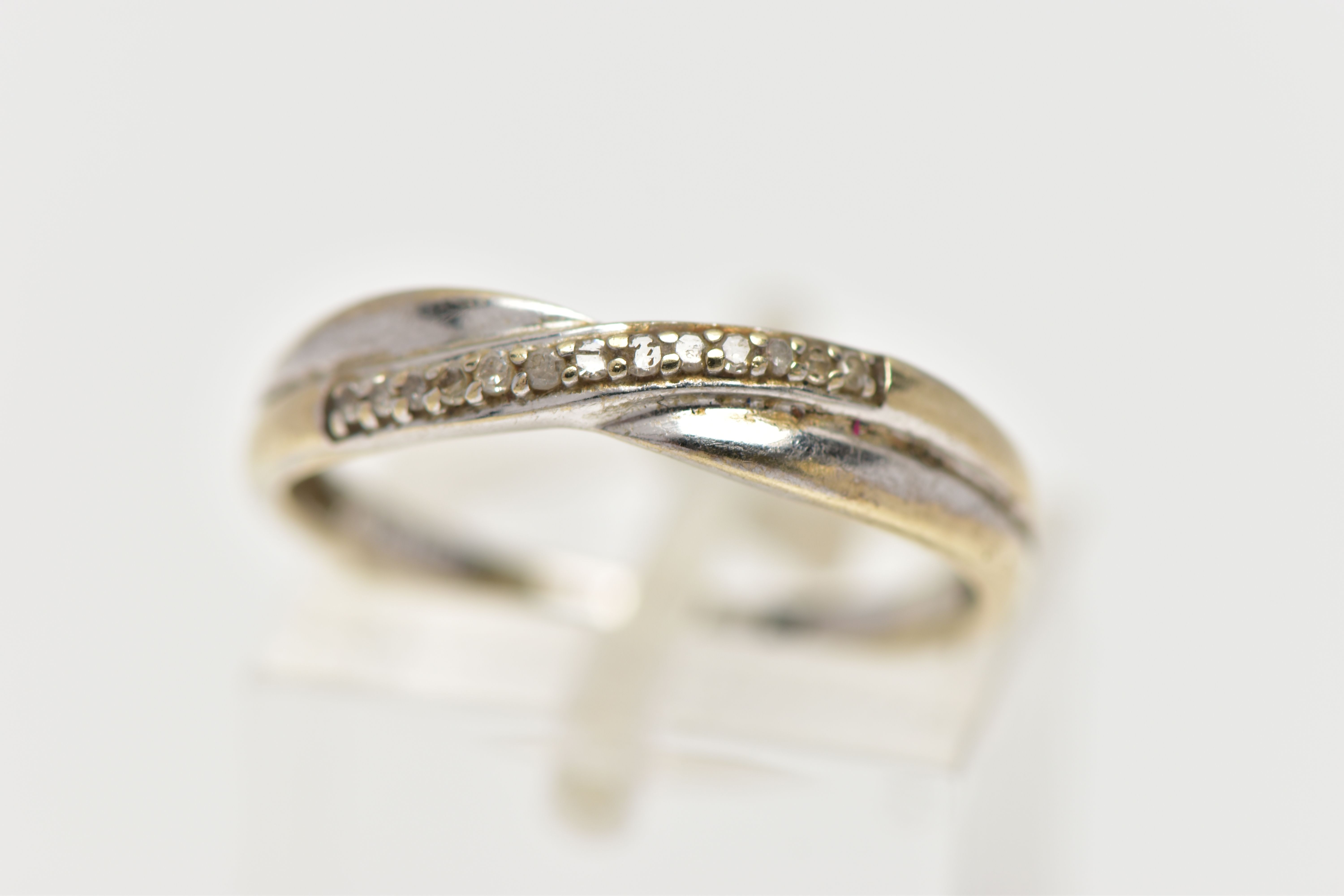 A 9CT WHITE GOLD DIAMOND DRESS RING, the single cut diamond line, set across an asymmetric plain