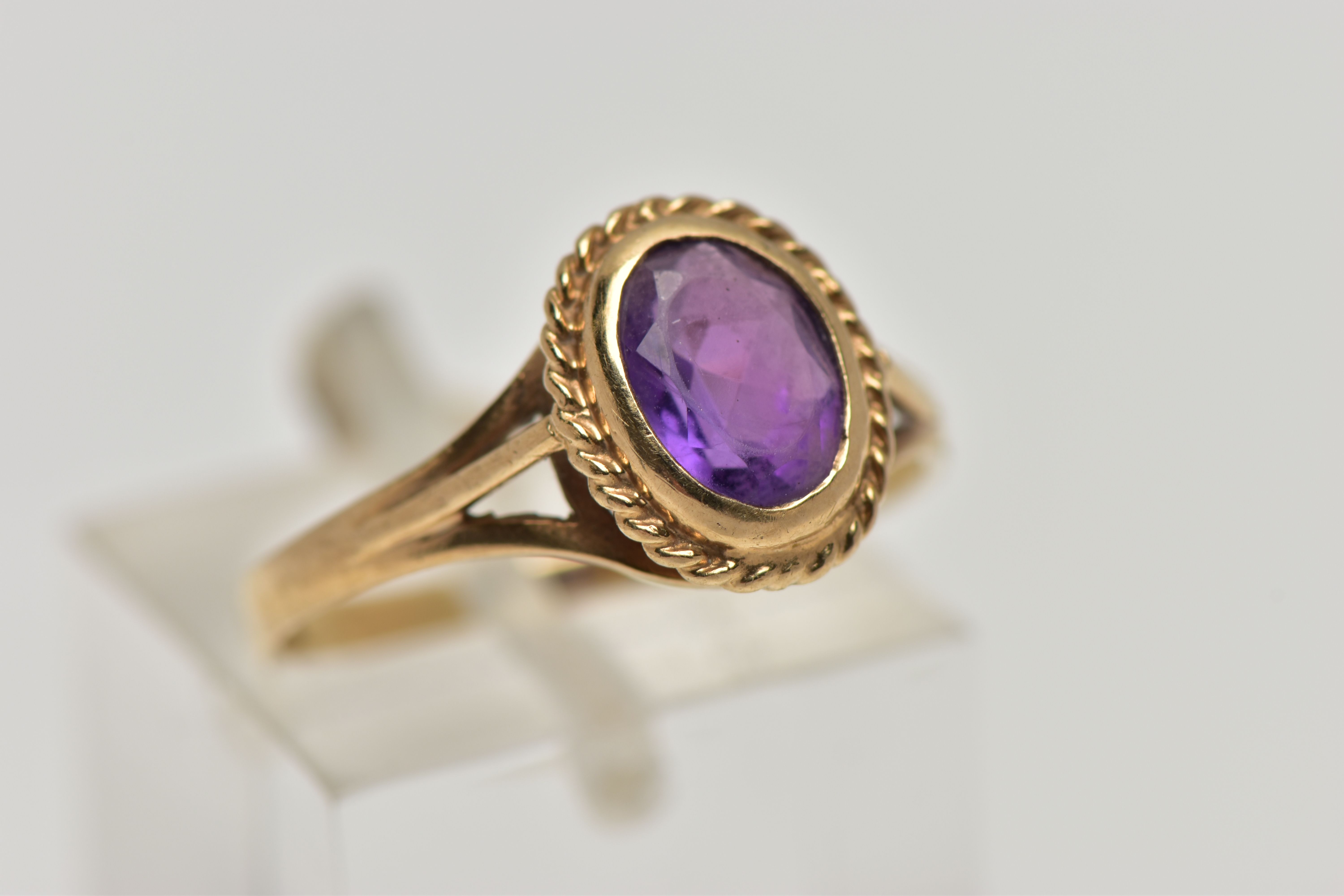 A 9CT GOLD AMETHYST SINGLE STONE RING, the oval cut amethyst within a collet setting, to the - Image 4 of 4