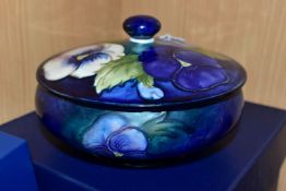 A BOXED MOORCROFT POTTERY 'BLUE PANSY' COVERED BOWL, of shallow squat form, having tube lined blue