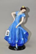 A 1930'S CONTINENTAL PORCELAIN FIGURE OF A LADY IN A LONG BLUE DRESS, modelled standing on an oval