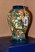 A BOXED MOORCROFT POTTERY 'SPIKE' BALUSTER VASE, having tube lined orange and yellow flowers with