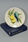 A BOXED MOORCROFT POTTERY COASTER IN THE BIRD AND LEMONS PATTERN ON A CREAM GROUND, impressed and