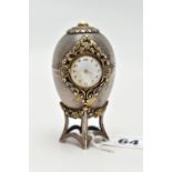 A 'ST JAMES HOUSE COMPANY' SILVER EASTER EGG CLOCK, featuring a small round clock with a white dial,