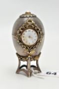 A 'ST JAMES HOUSE COMPANY' SILVER EASTER EGG CLOCK, featuring a small round clock with a white dial,