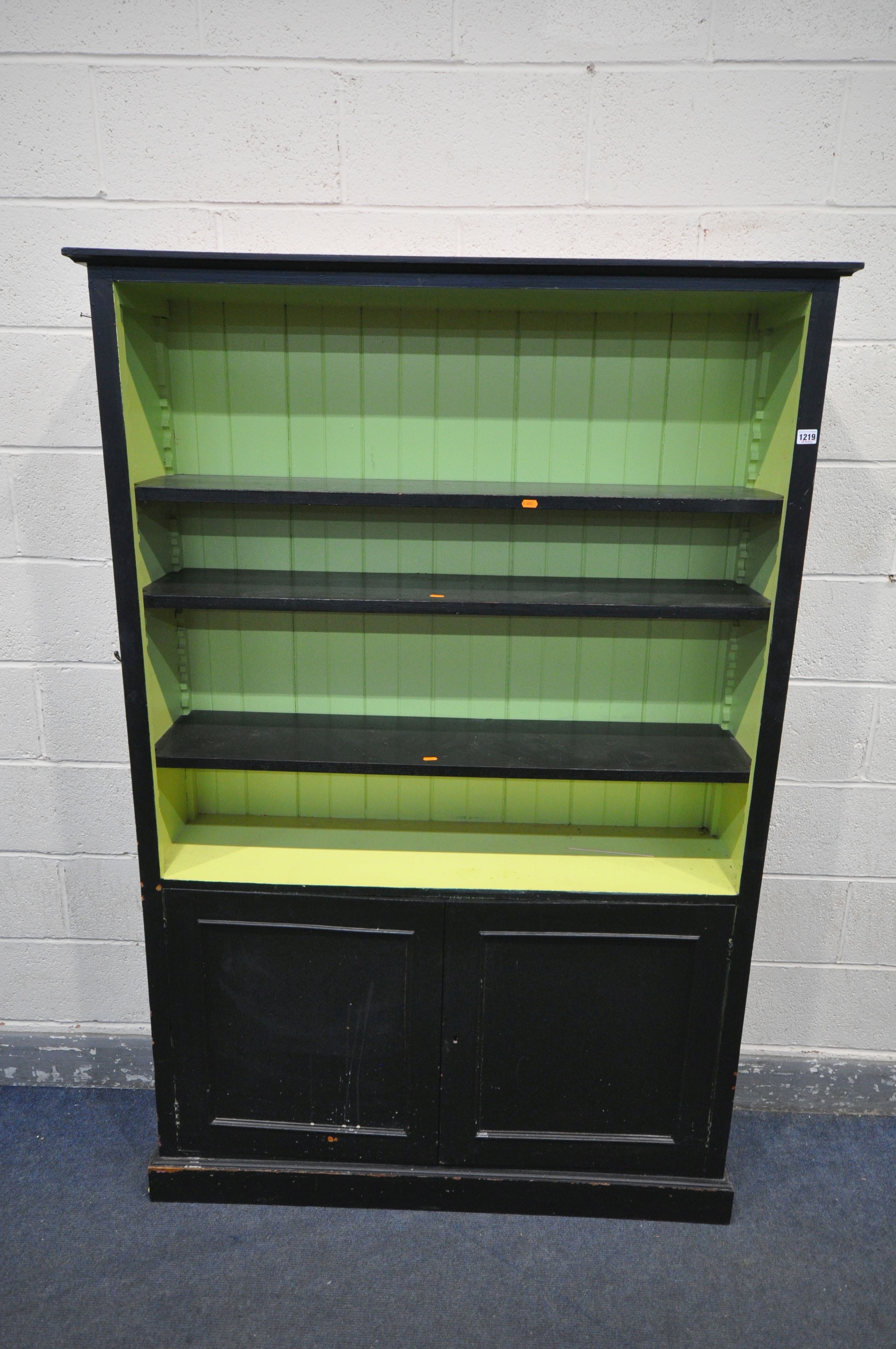 A PAINTED BOOKCASE, with three shelves over two cupboard doors (condition - painted in three