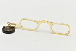 A PAIR OF YELLOW PLASTIC FRAMED GLASSES WITH SHORT ANGULAR HANDLE, fitted with a circular black