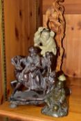 FOUR ORIENTAL FIGURES, to include a hollow cast brass figure of a seated man with a book, height