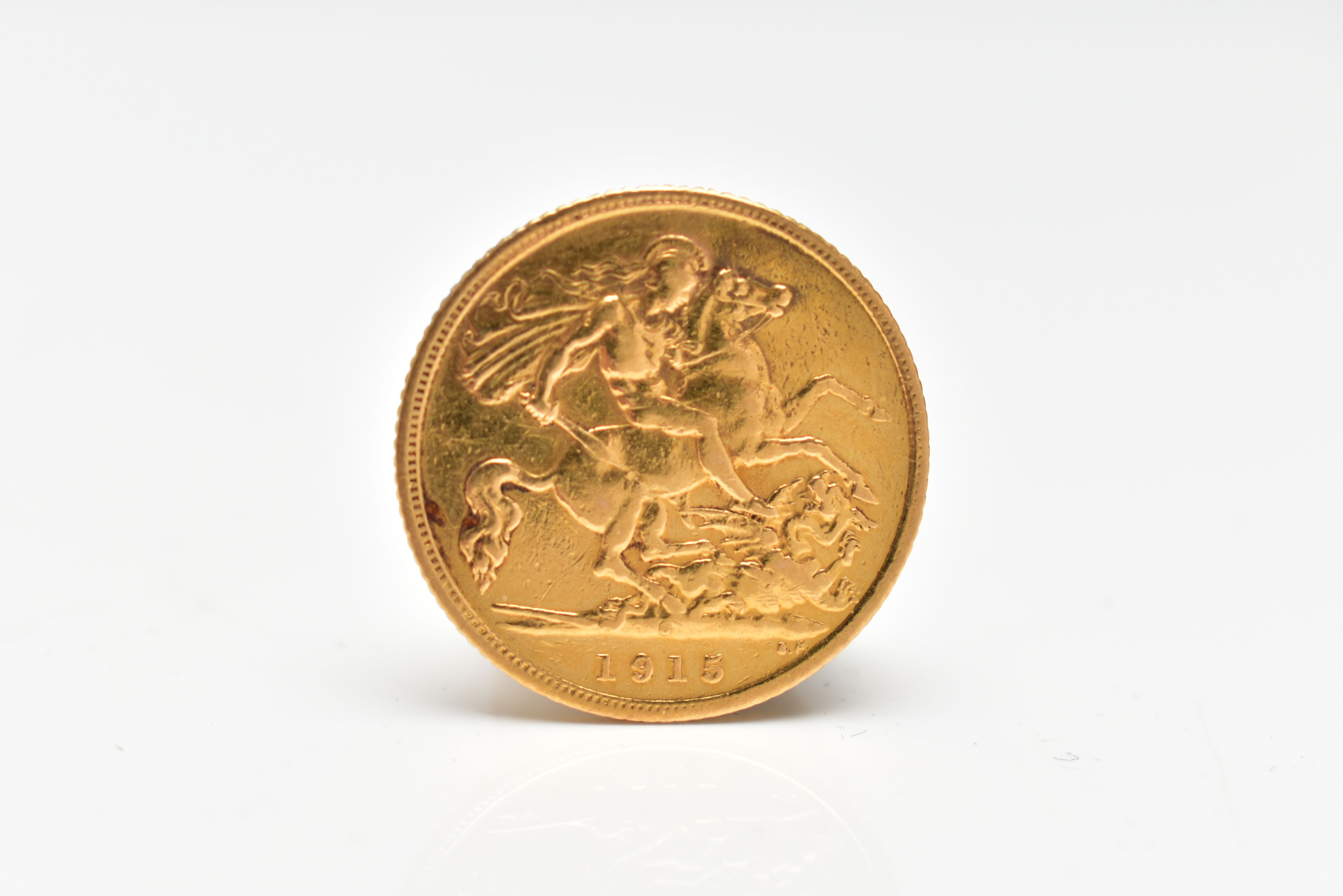 A GEORGE V HALF SOVEREIGN COIN, obverse depicting George V, reverse displaying George and the