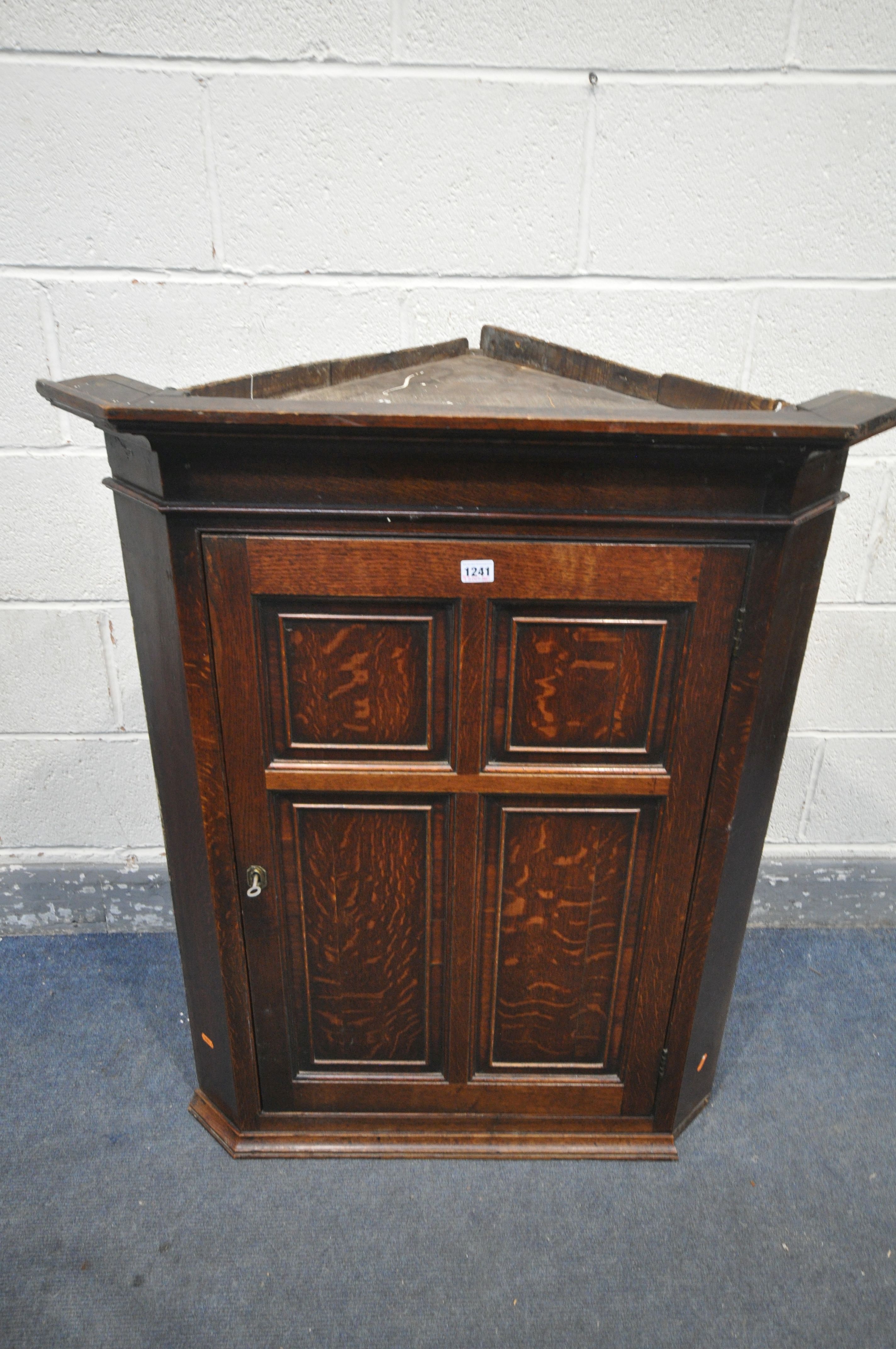 A GEORGIAN OAK SINGLE PANEL DOOR HANGING CORNER CUPBOARD, enclosing two shelves (condition - loose