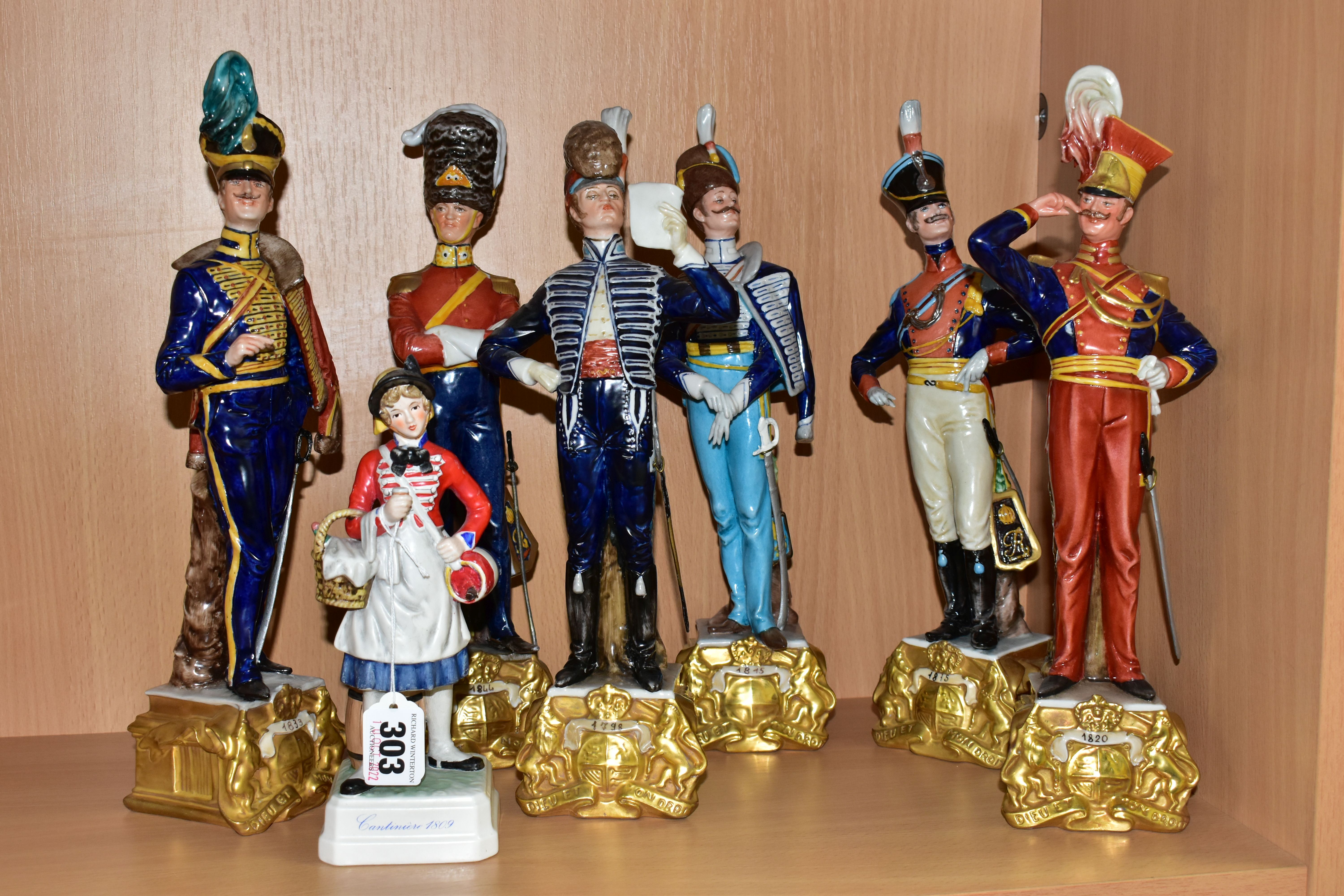SIX CAPODIMONTE BRUNO MERLI FIGURES OF SOLDIERS IN HISTORICAL COSTUME OF 1798-1844 AND A GOEBEL