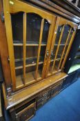 A TWO DOOR BOOKCASE, top with two glazed doors, base with five various drawers and two doors (