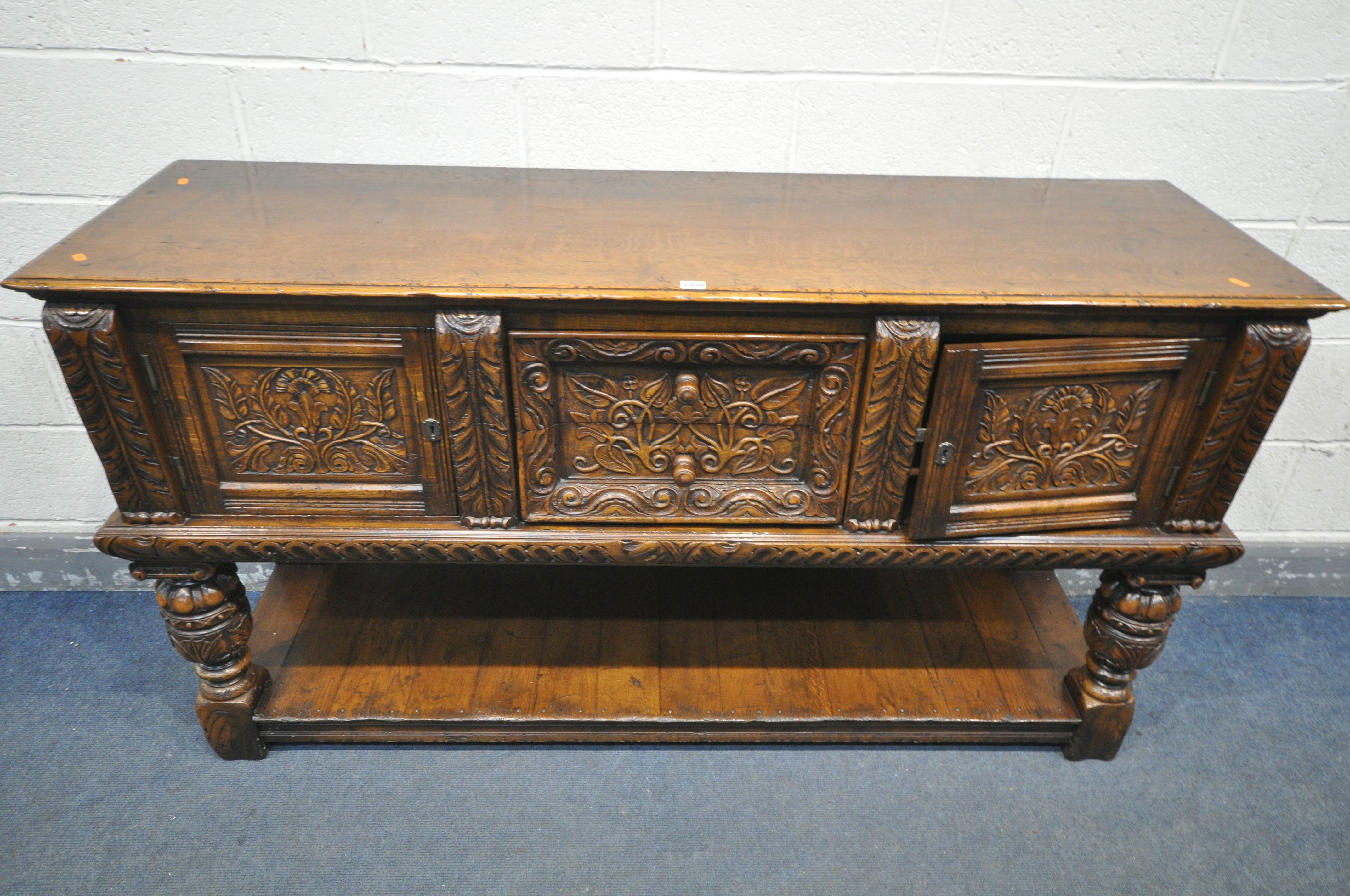 A REPRODUCTION SOLID OAK DRESSER BASE, with two cupboard doors, flanking two drawers, on twin