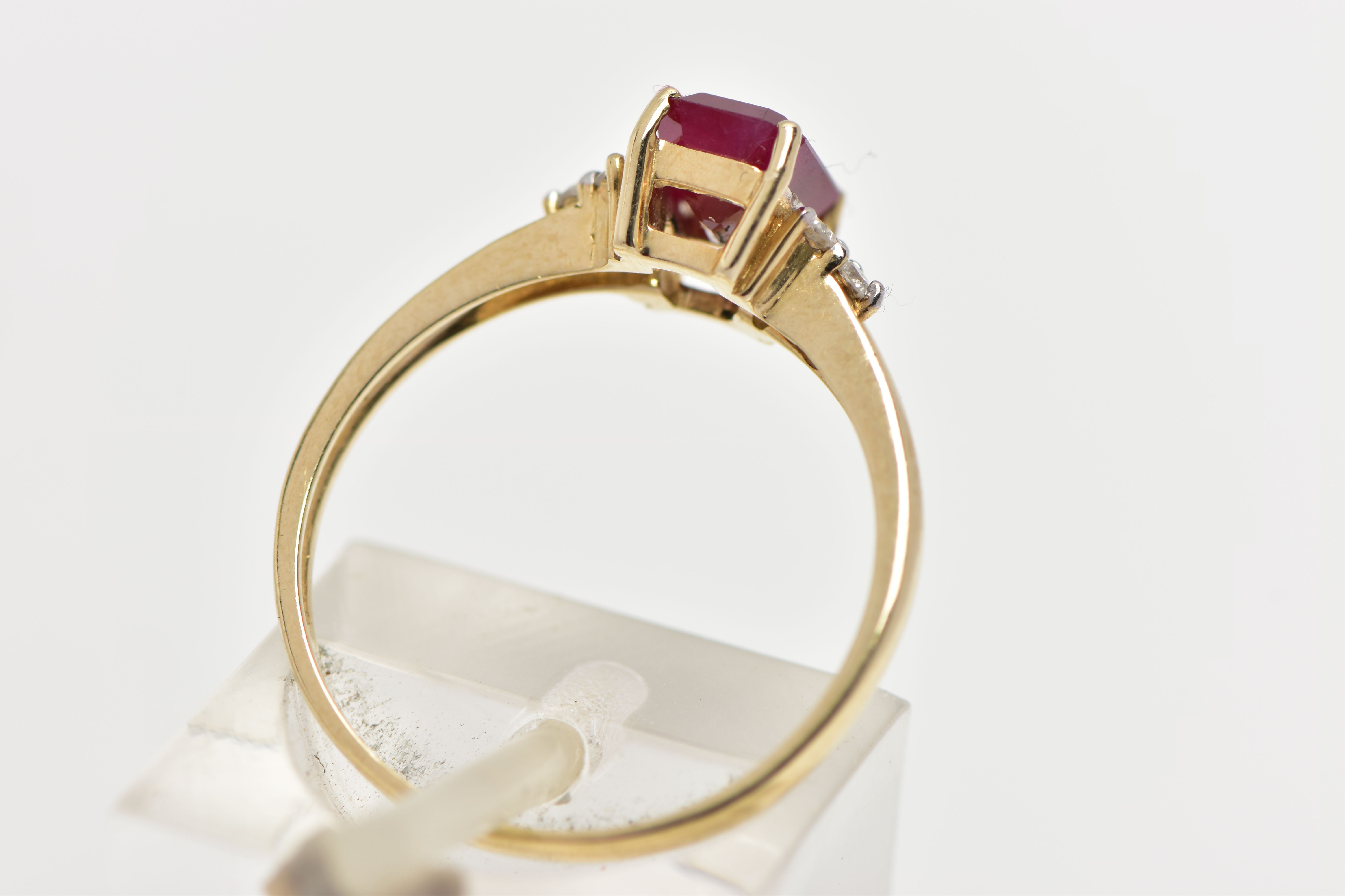 A YELLOW METAL GEM SET RING, designed with a central four claw set, rectangular cut synthetic - Image 3 of 4