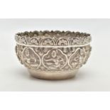 A SILVER EMBOSSED BOWL, circular bowl featuring various religious figures and floral patterns,