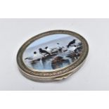 A WHITE METAL HINGED TRINKET BOX, of an oval form, depicting seagulls on rocks to the cover,