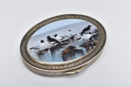 A WHITE METAL HINGED TRINKET BOX, of an oval form, depicting seagulls on rocks to the cover,