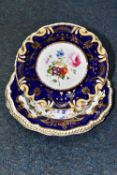 TWO HANDPAINTED SOUP BOWLS AND A PLATE, painted with flowers within a cobalt blue border with gilt