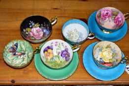 SIX AYNSLEY CABINET CUPS AND THREE SAUCERS, comprising a green cup and saucer, the interior of the