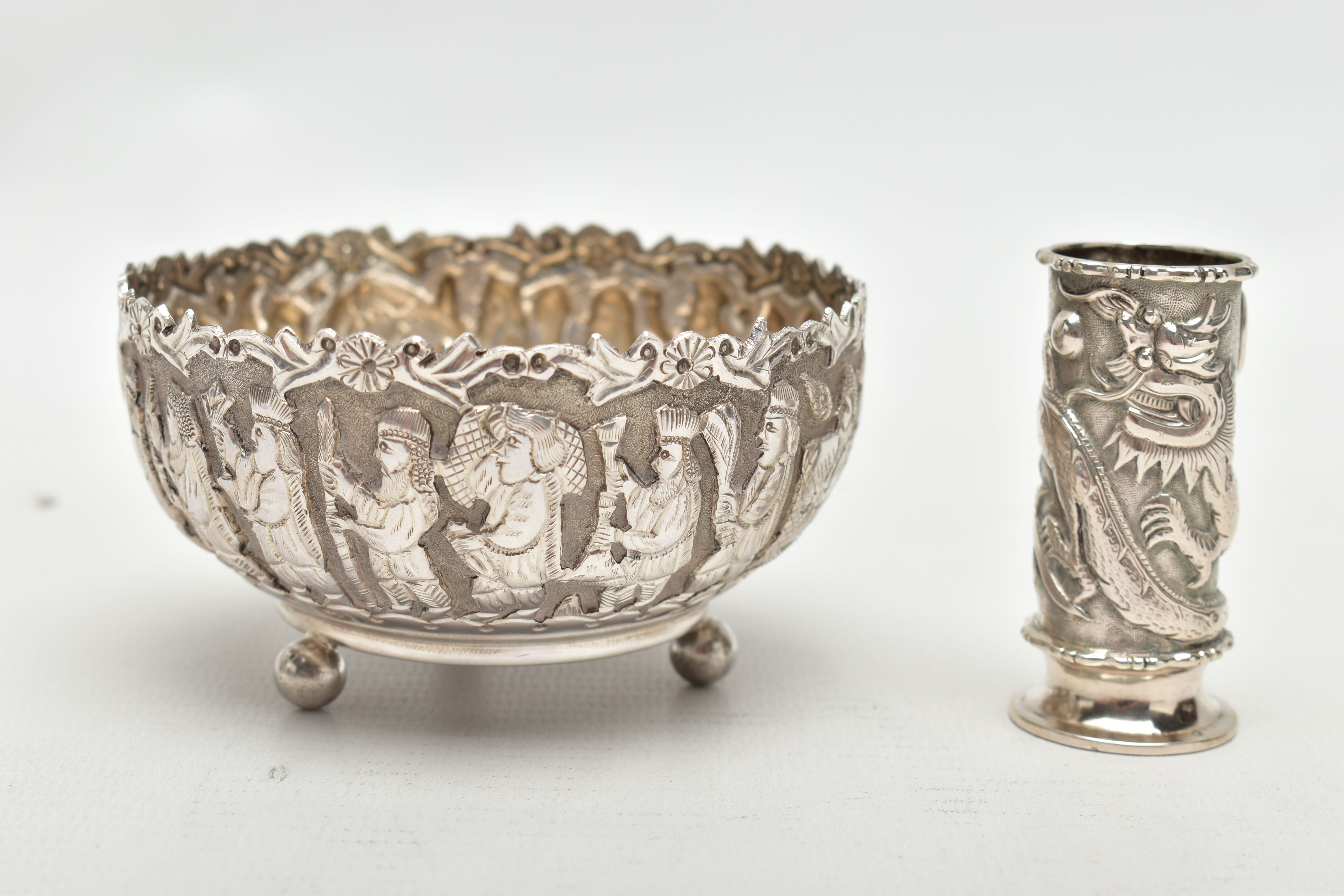AN EMBOSSED WHITE METAL BOWL AND SMALL VASE, the round bowl decorated with embossed multiple figural