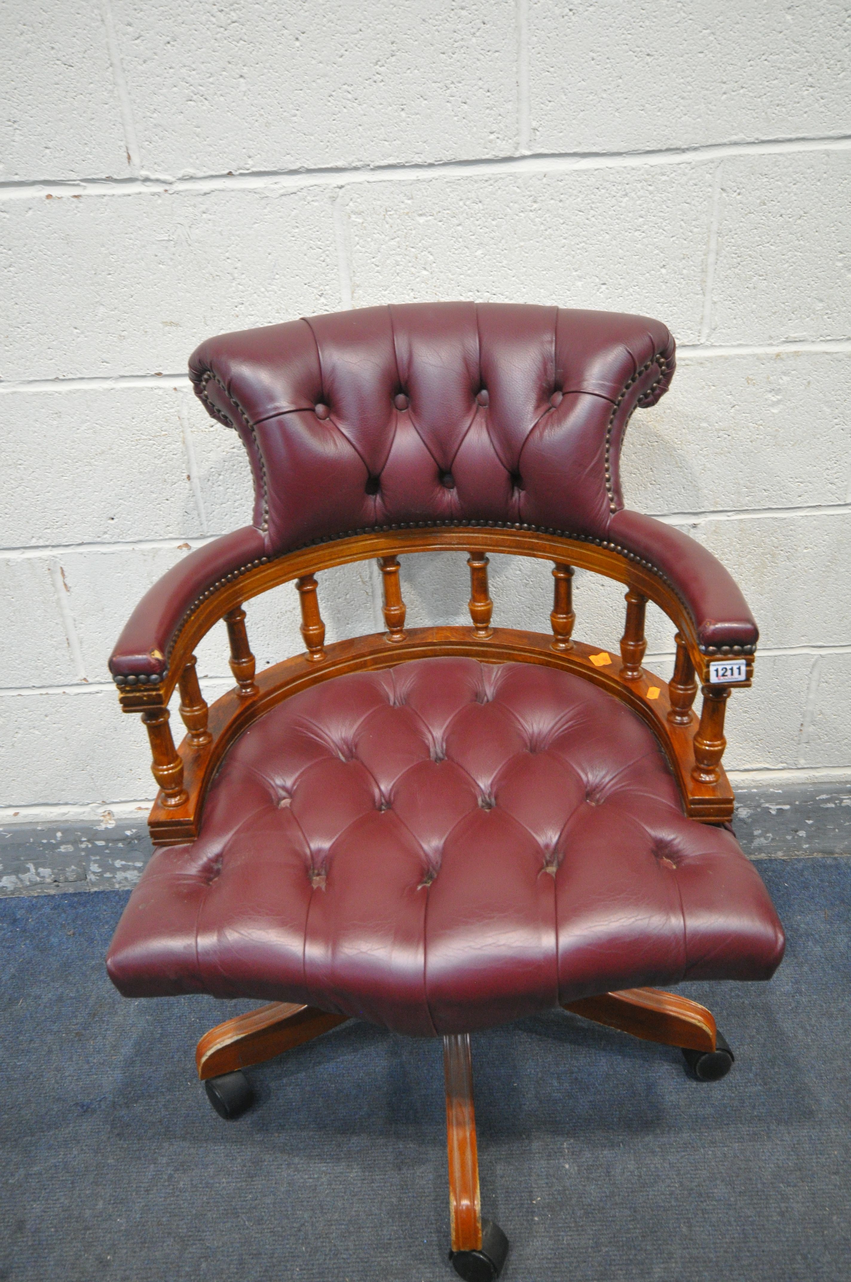 A BURGUNDY LEATHER SWIVEL OFFICE CHAIR, with buttoned back and seat, width 64cm x depth 69cm x